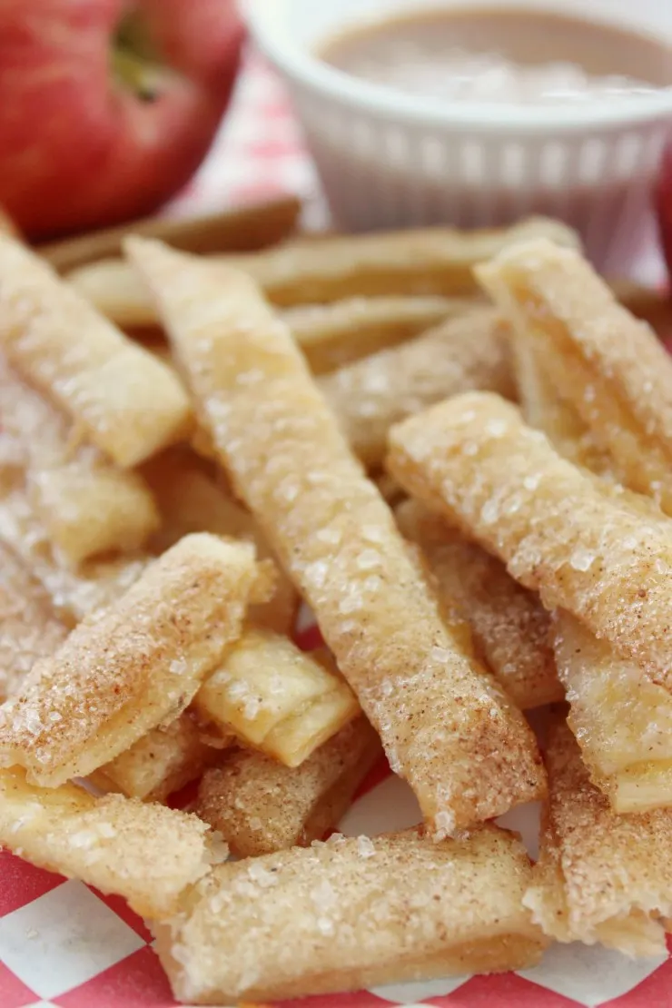 These Apple Pie Fries are a fun dessert that look like french fries but taste like apple pie! Pie crust cut into strips and filled with apple pie filling then baked to crispy perfection. Dip them in caramel sauce to satisfy any sweet tooth!