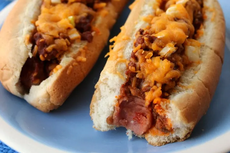 Chili Cheese Dogs are an American Classic - Hotdogs Smothered in Chili Con Carne, Cheddar Cheese and Onion.