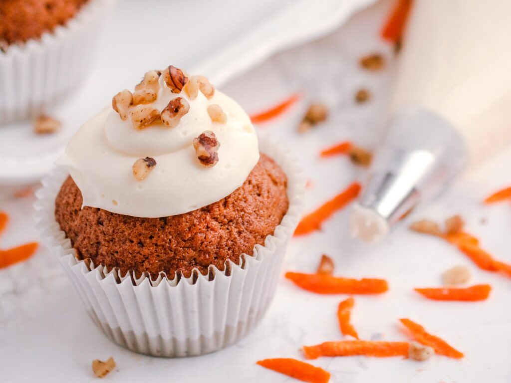 Soft and moist carrot cupcakes, this recipe results in a spiced carrot cake topped with homemade cream cheese frosting!