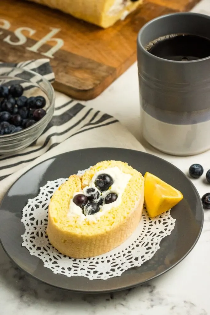Whipped cream cheese frosting & fresh blueberries fill this Blueberry Lemon Cake Roll (Swiss Roll) a delicious dessert that gets rave reviews!