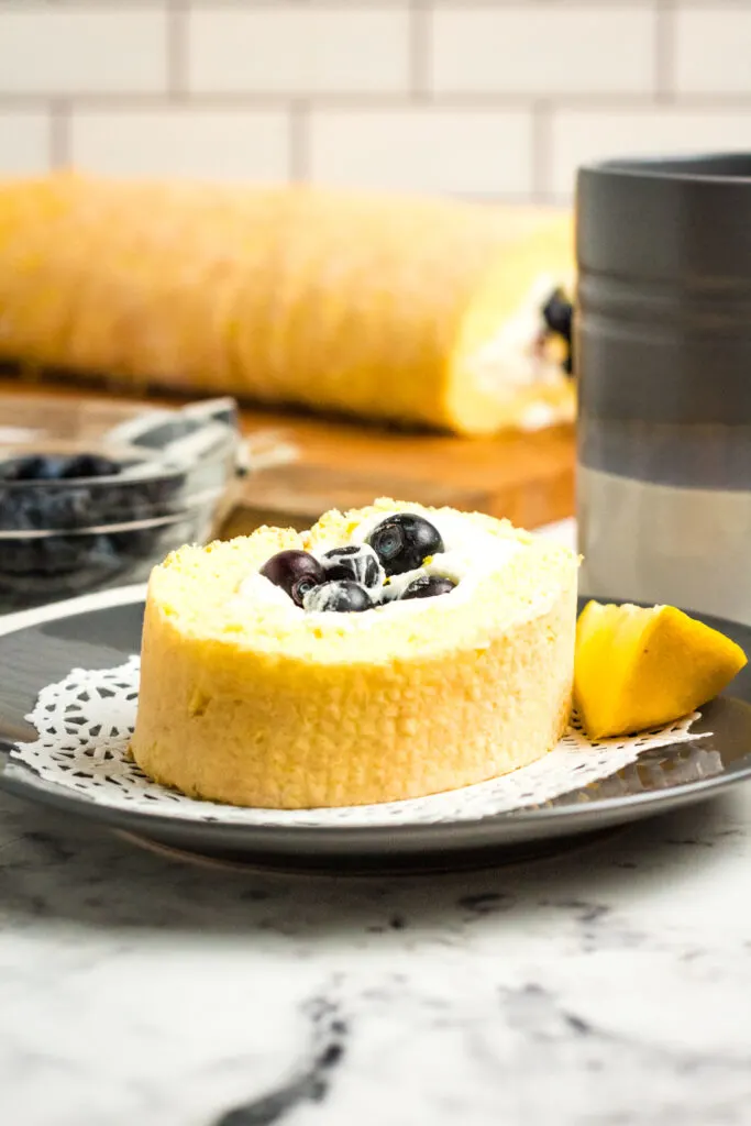 Whipped cream cheese frosting & fresh blueberries fill this Blueberry Lemon Cake Roll (Swiss Roll) a delicious dessert that gets rave reviews!