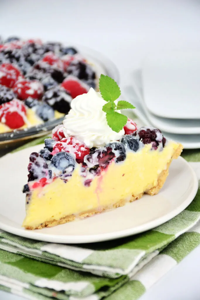 A luscious triple berry cream pie recipe featuring a creamy filling topped with Blackberries, Raspberries & Blueberries covered in chocolate.