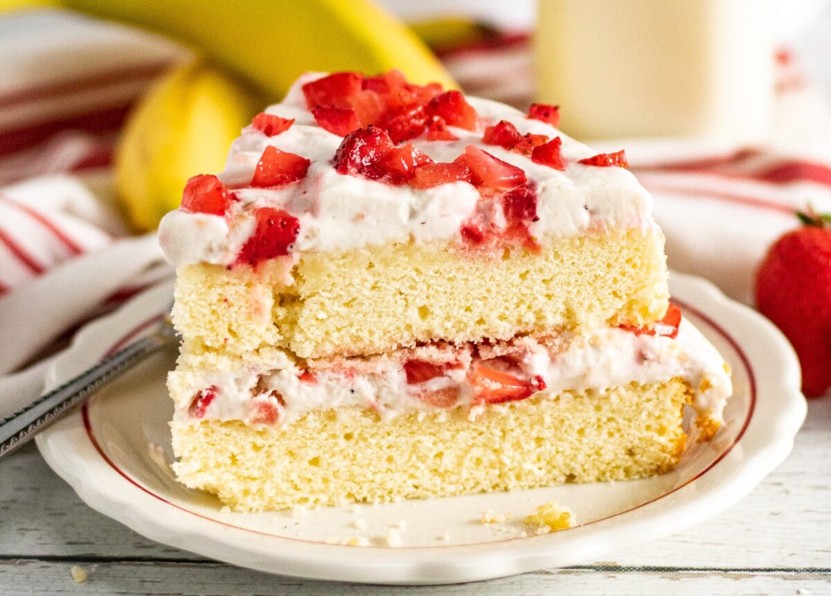An easy recipe for a strawberry banana layer cake with layers of creamy whipped cream frosting made with fresh bananas and strawberries.