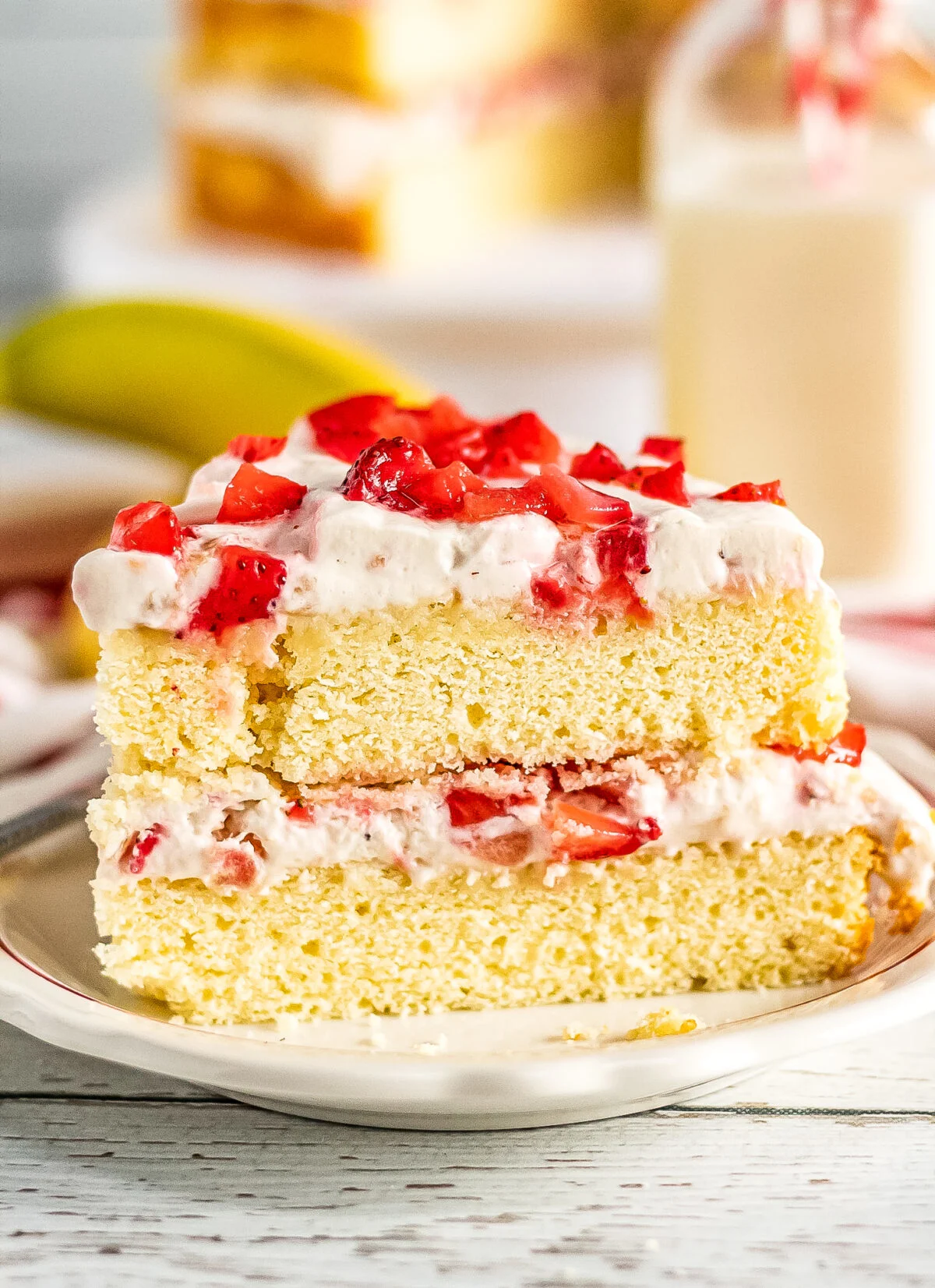 An, easy recipe for a strawberry banana layer cake with layers of creamy whipped cream frosting made with fresh bananas and strawberries.