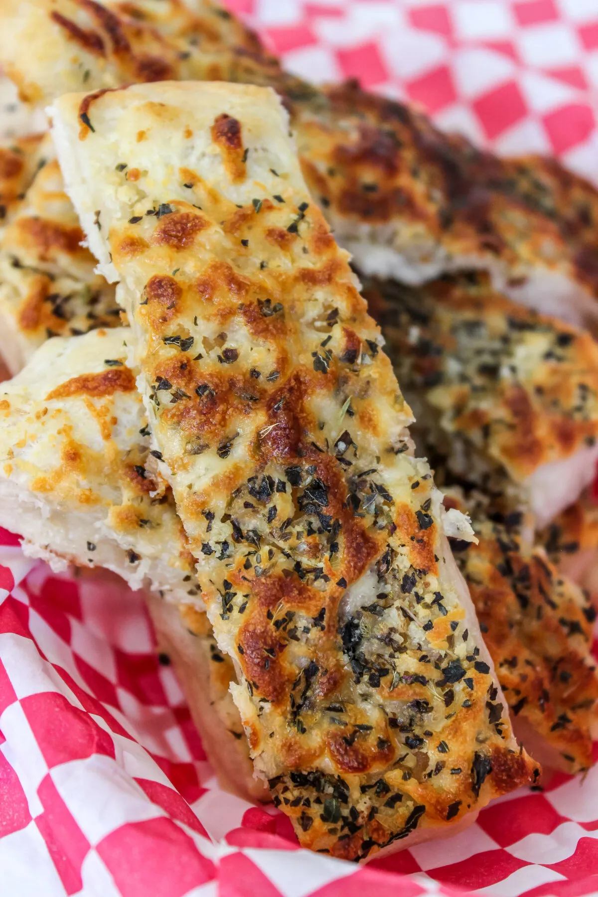 These cheesy garlic breadsticks are made from pizza dough for a delicious twist on the classic! It's a hit as a side dish or appetizer.