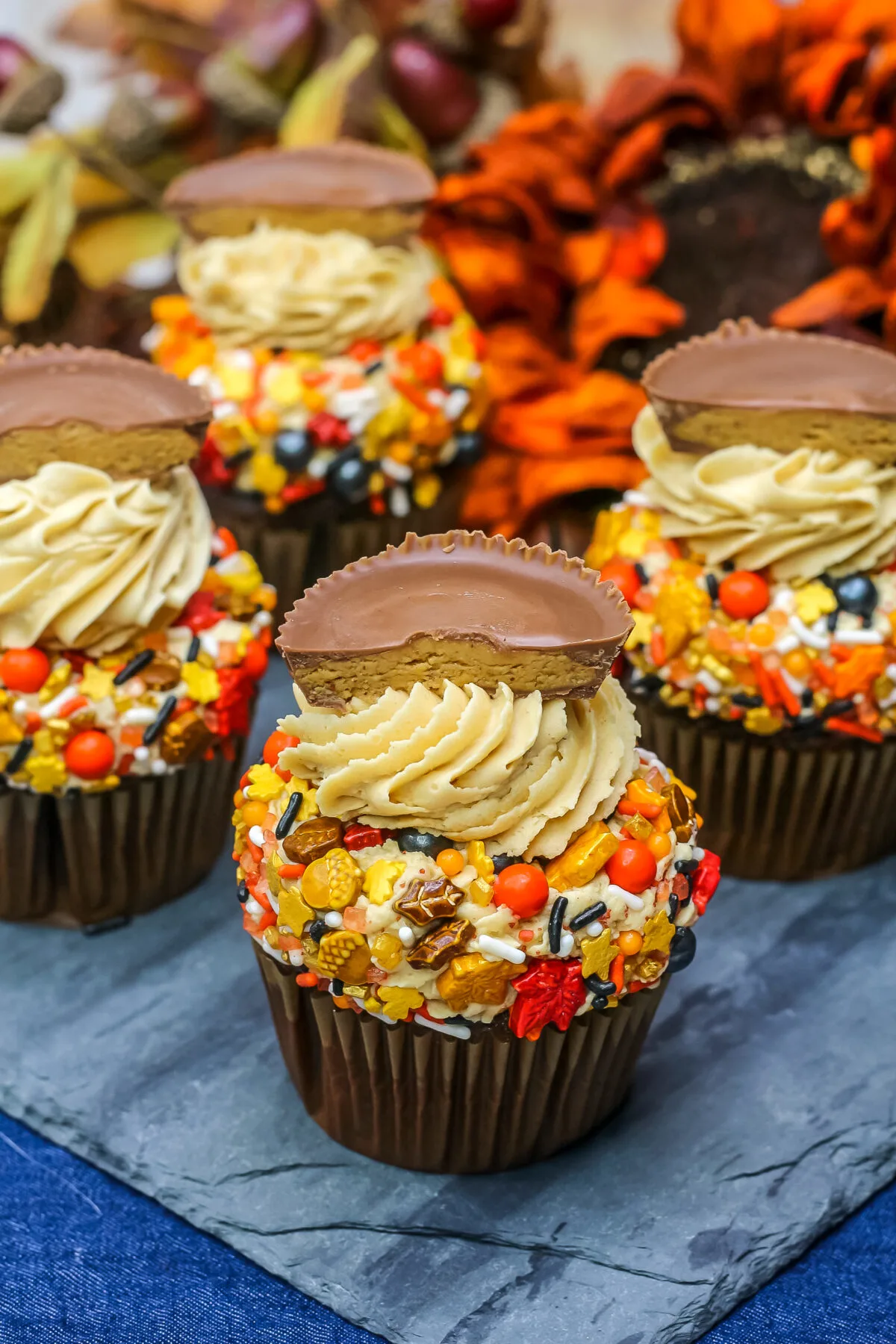 This chocolate cupcakes with peanut butter frosting recipe features a rich chocolate cake, creamy frosting, cute sprinkles and a Reese’s cup.