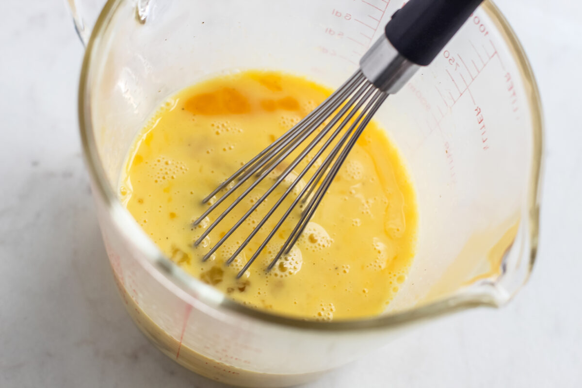 Egg whisked in a measuring cup.