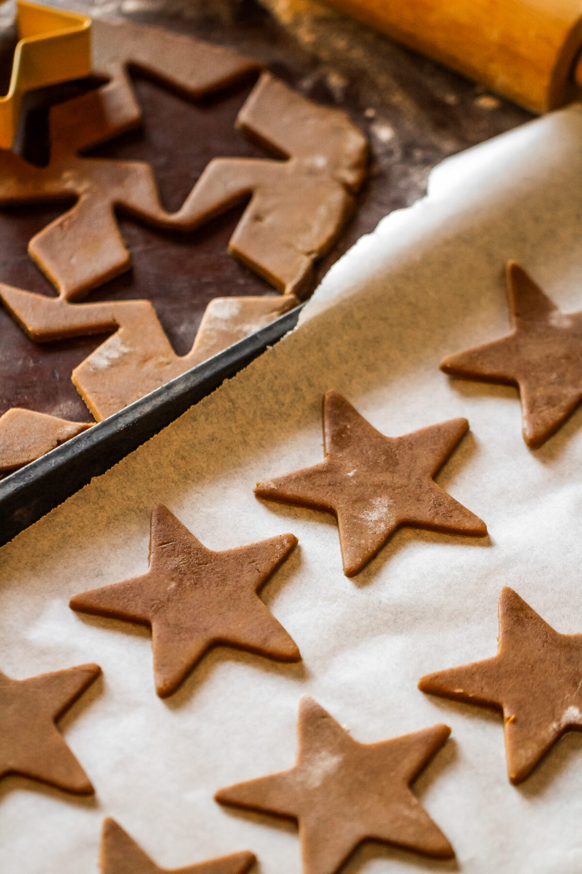 Gingerbread stars laid out on a sheet pan.