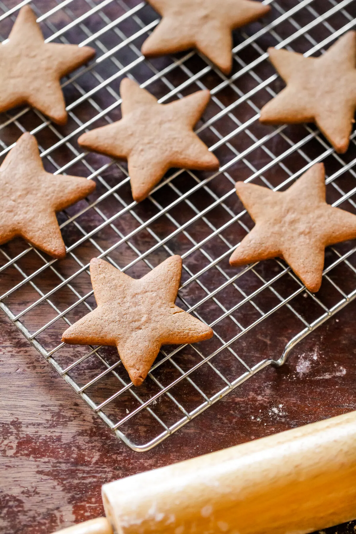 Baked gingerbread stars on a cooling sheet.