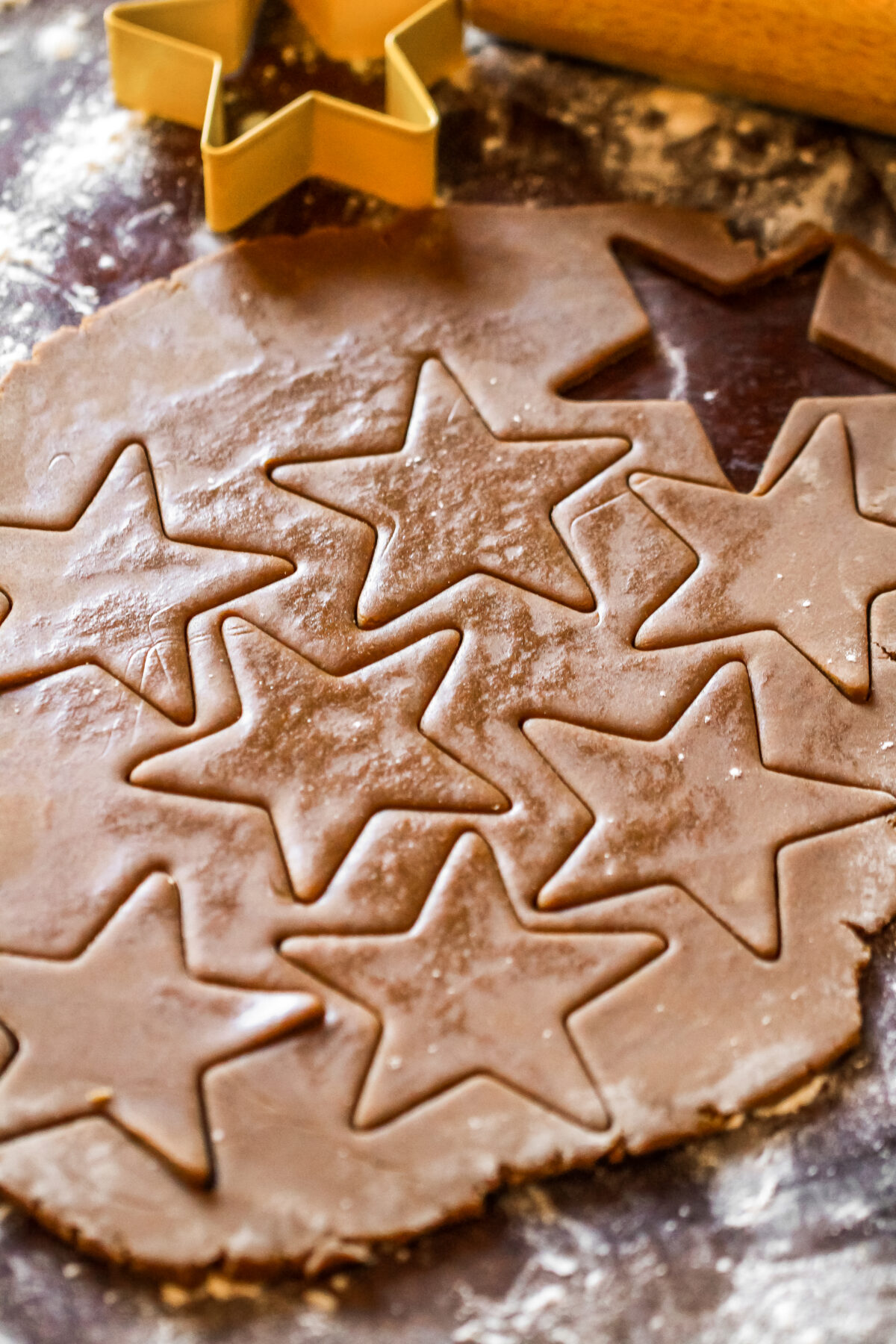 stars being cut out of gingerbread dough.