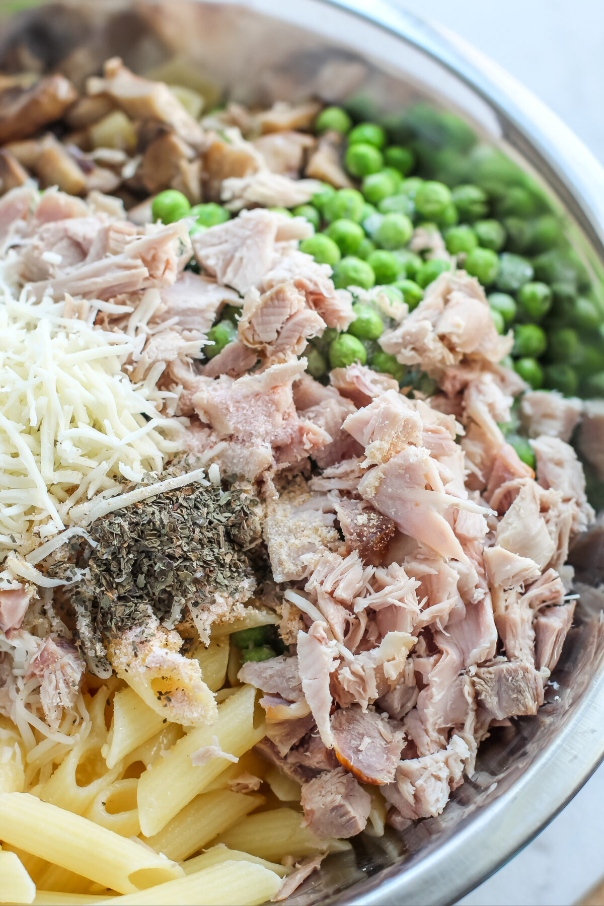 Pasta, turkey, peas, cheese and seasonings in a large bowl.