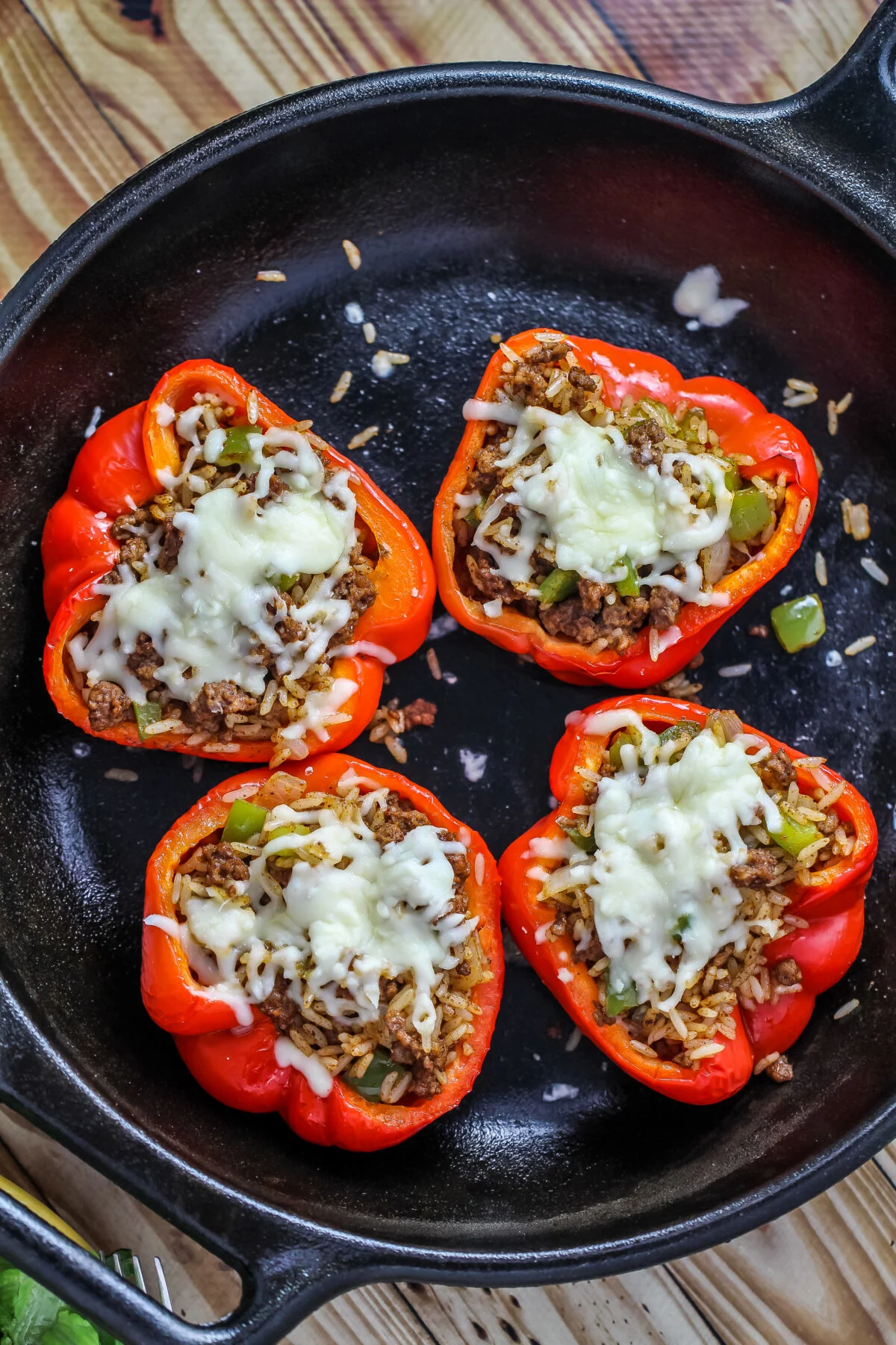 The BEST stuffed peppers for weeknight dinners! Ground beef and rice combine with melted monterey jack cheese for a hearty meal!