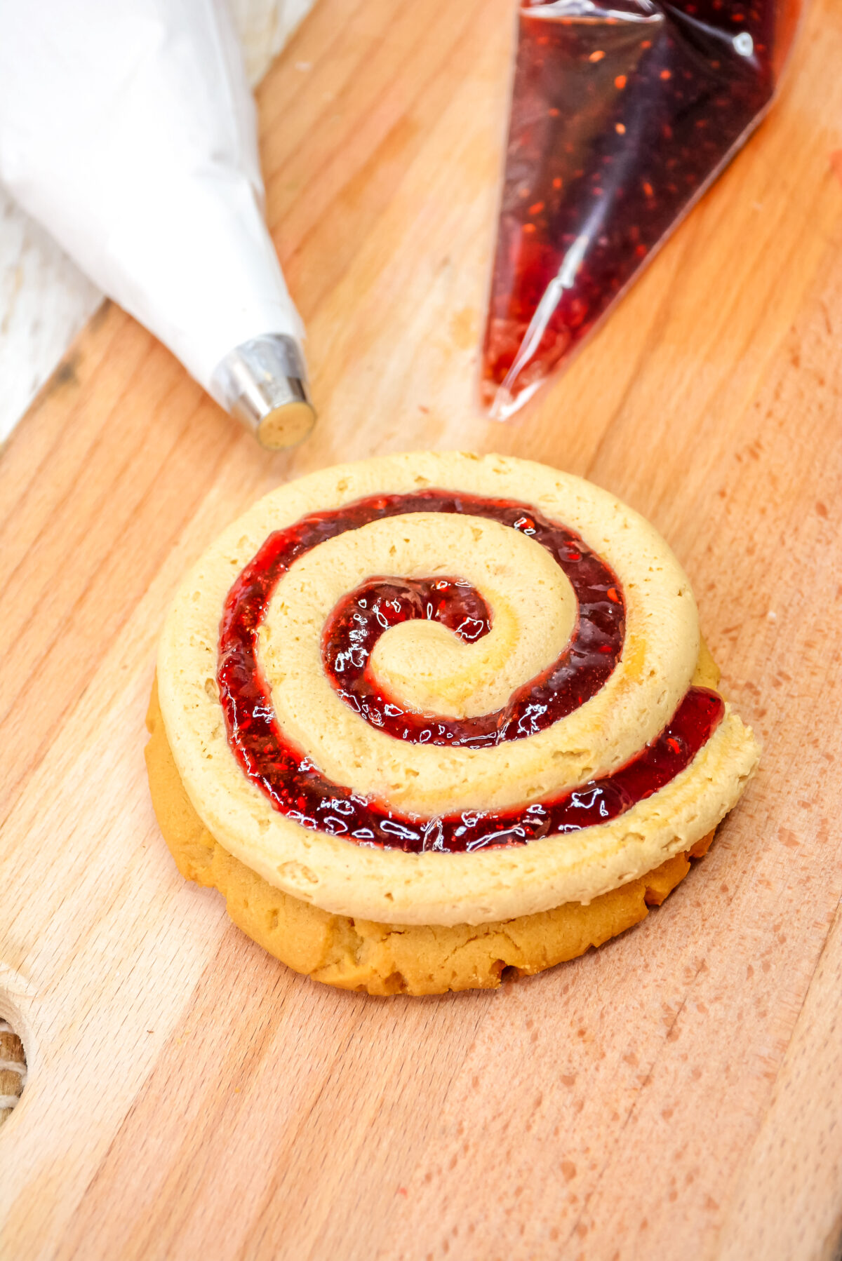 A spiral of jam piped on the peanut butter cookie.