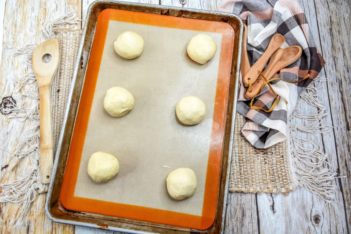 Dough balls formed and placed on a baking sheet lined with a silicone baking mat.
