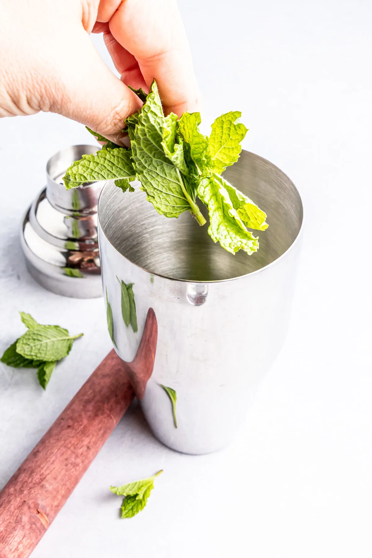 Putting mint into a cocktail shaker.