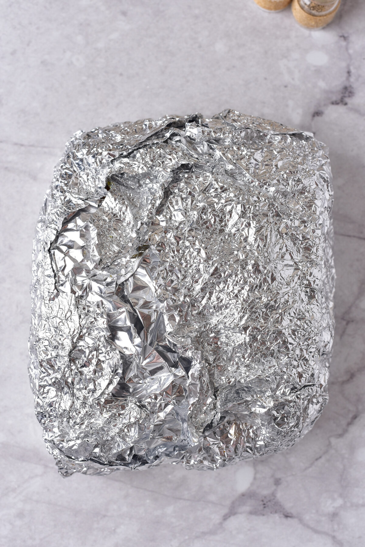 Pork loin wrapped in aluminum foil.