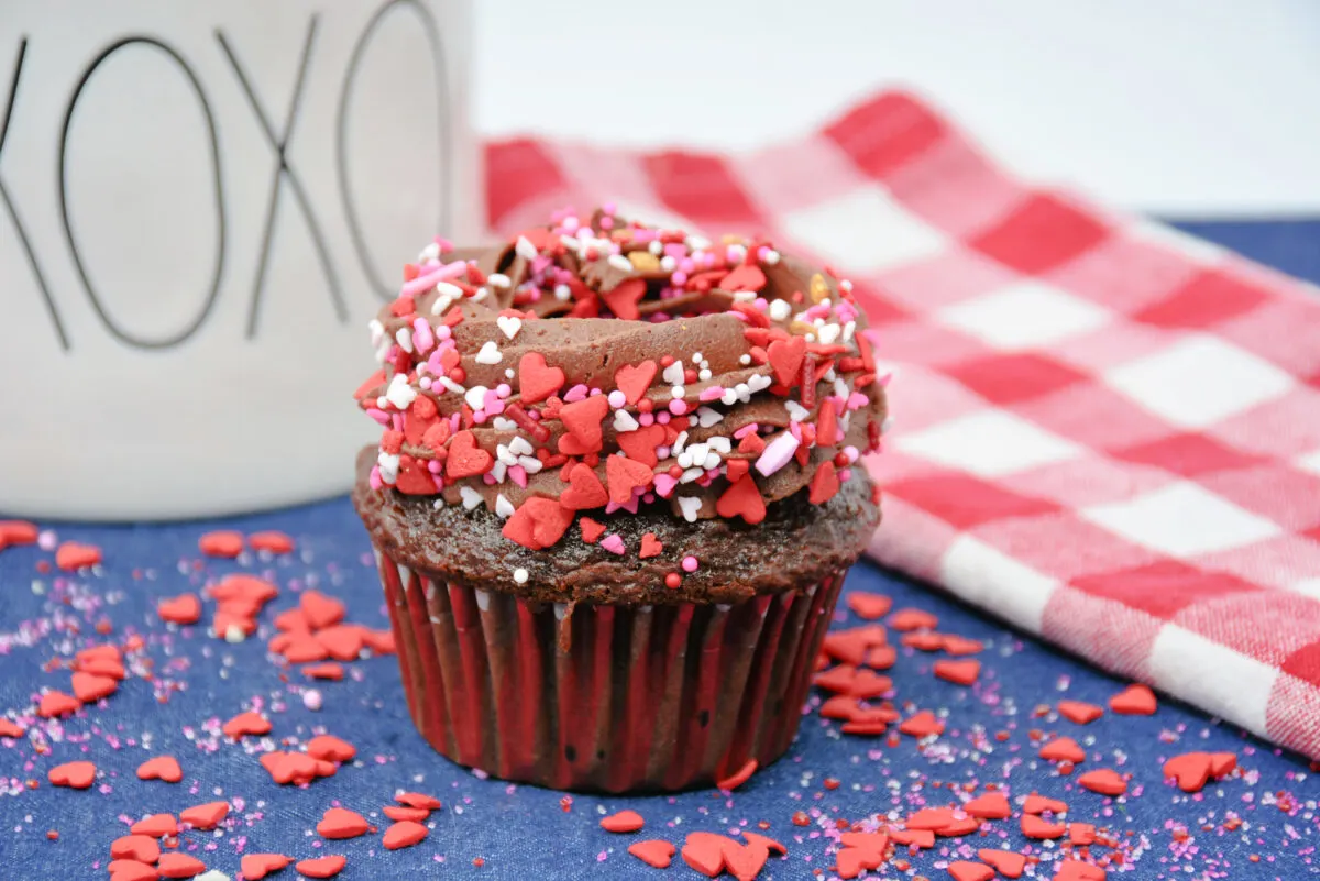 Sprinkles over the chocolate frosting on the cupcake.