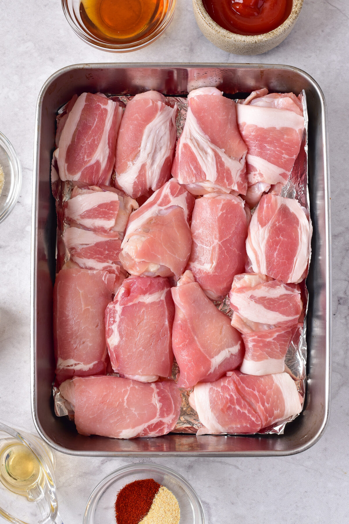 Wings wrapped in bacon and arranged in the baking dish.