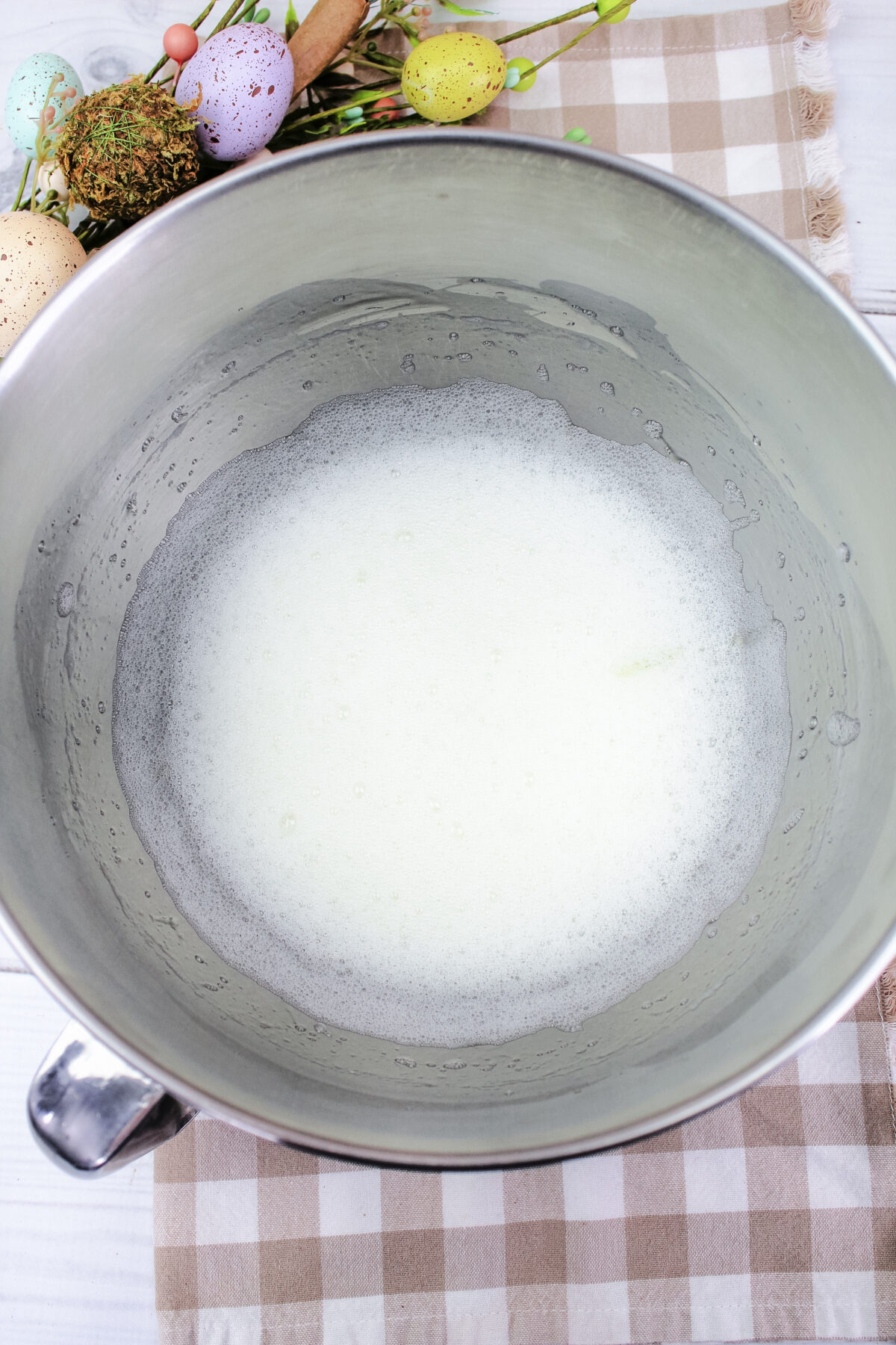 Foamy egg whites in a mixing bowl.