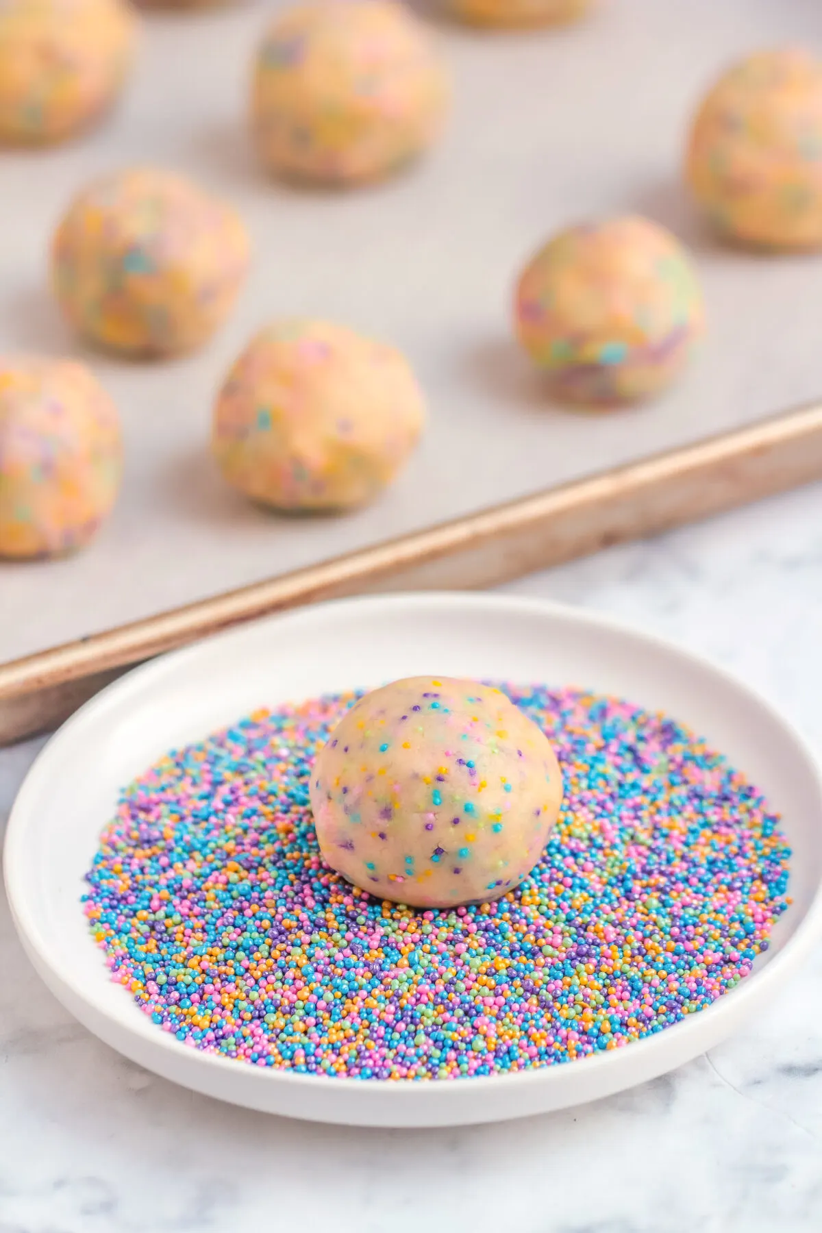 Cookie dough pressed into a plate full of sprinkles.