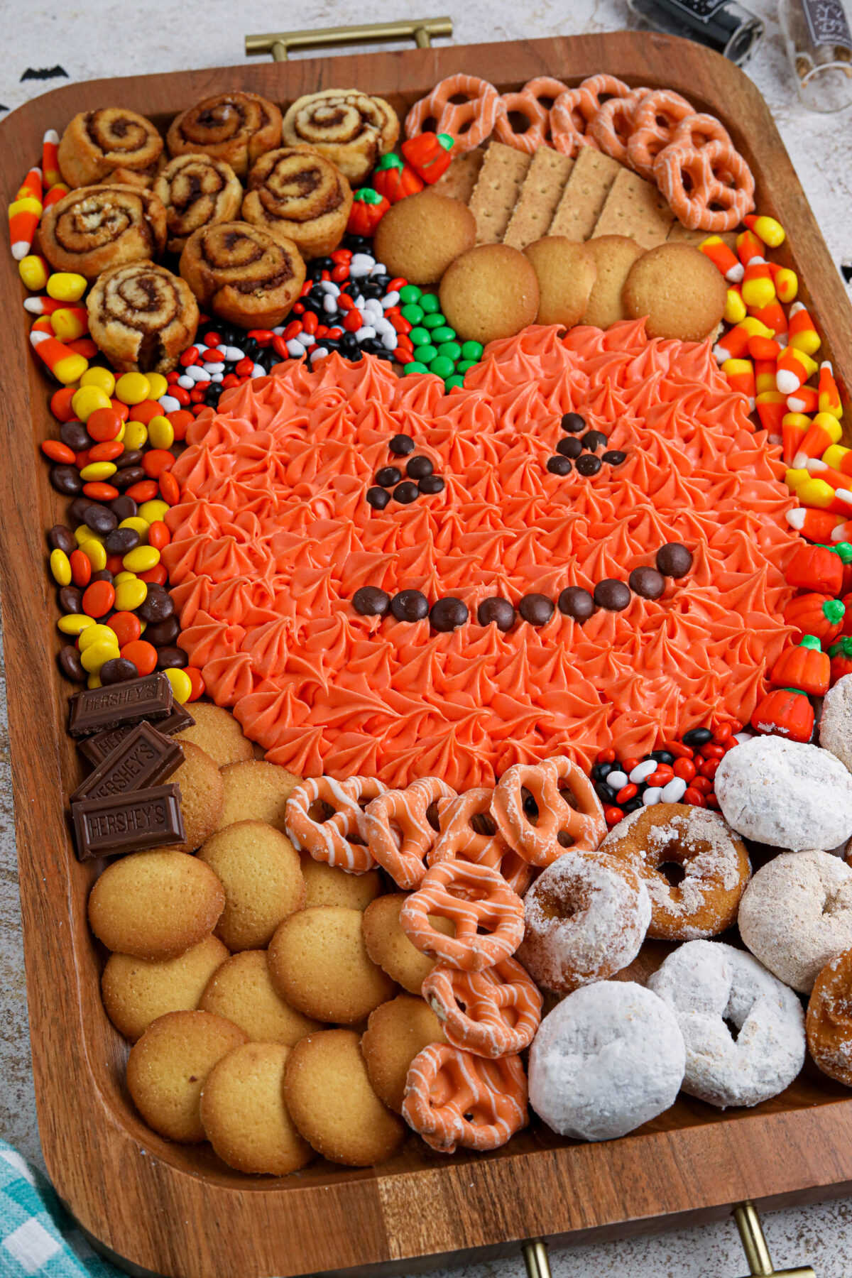 Make your Halloween party one to remember with this easy pumpkin frosting board featuring homemade orange frosting and fun dippers!