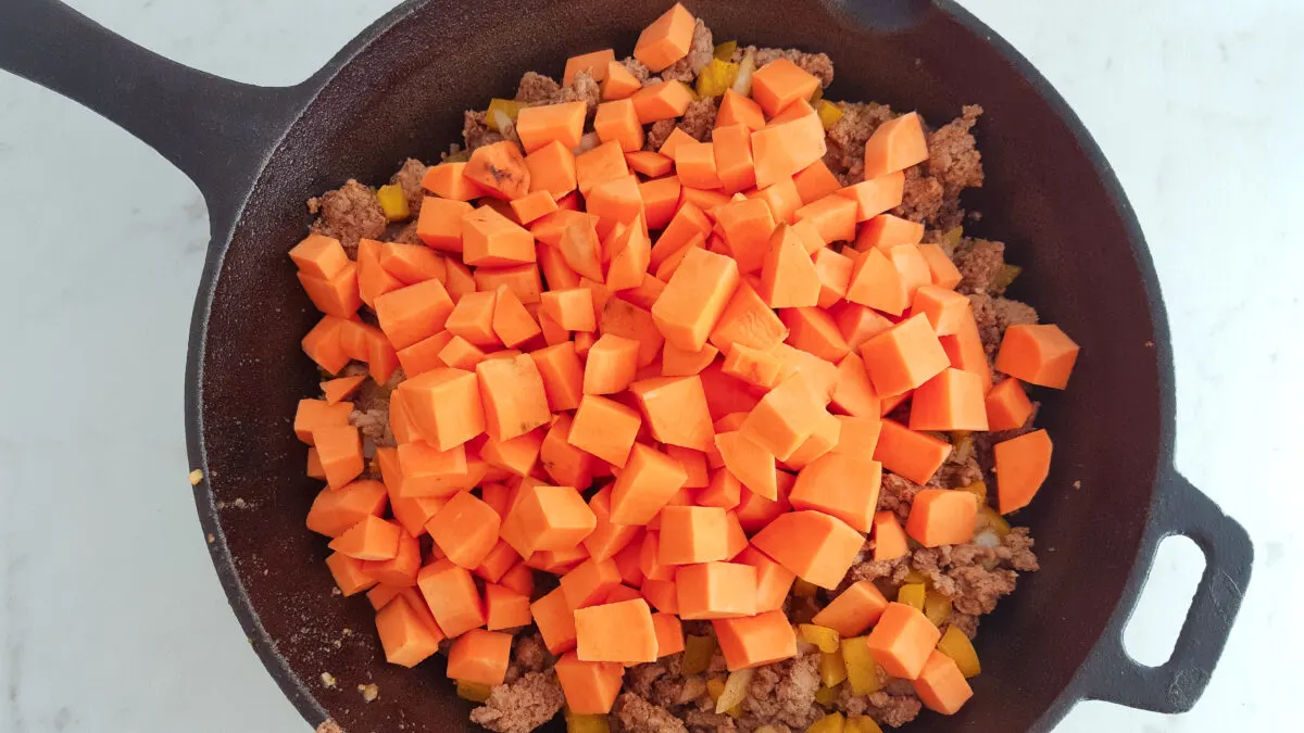 Sweet potatoes added to the skillet.